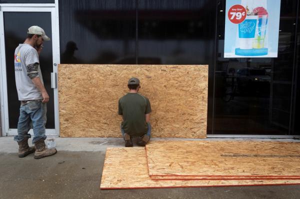 Men work boarding up a window as Tropical Storm Francine intensifies and is on track to become a hurricane before its expected landfall on the U.S. Gulf Coast, in Morgan City, Louisiana, U.S. September 10, 2024.
